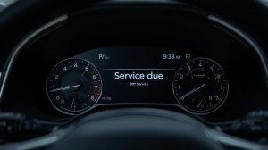 Painel de carro com a mensagem 'service due' destacada, alertando para a necessidade de manutenção.
